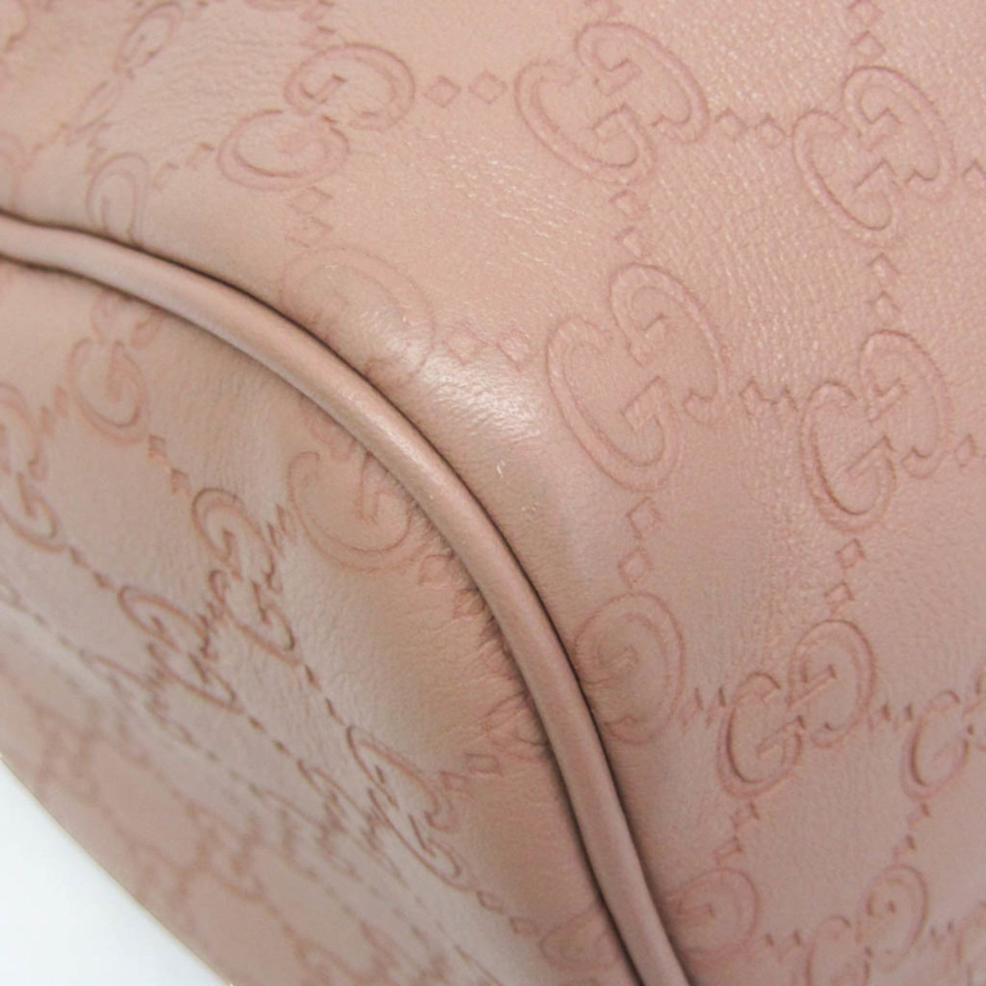 Gucci Guccissima blush pink leather Boston bag with embossed monogram detail.